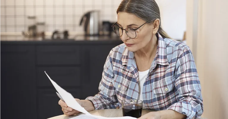 Mujer revisando documentos relacionados con la reliquidación de pensión por semanas cotizadas superiores a 1.800 en Colombia.